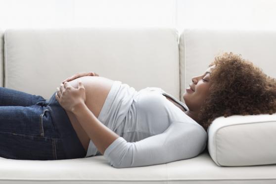 A pregnant woman lying down on a sofa